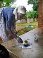 Mama Mtetwa Grinding Charcoal